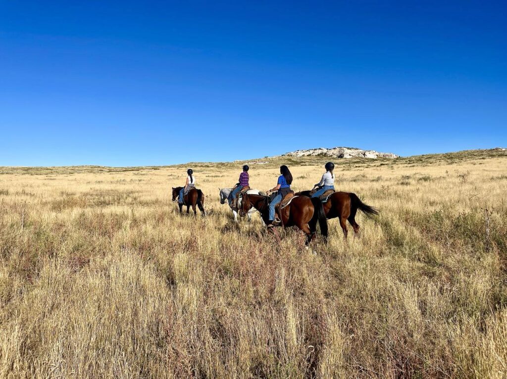 Participants at a mini ranch clinic riding out for a day of horsemanship and ranch work.